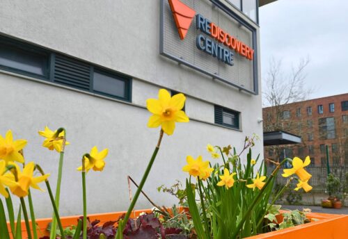 Bild zeigt Rediscovery Center in Dublin von außen, im Vordergrund ist ein Blumenbeet.