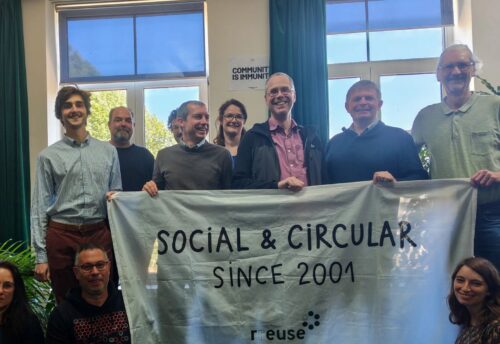 Bild zeigt mehrere Teilnehmer:innen beim RREUSE Netzwerktreffen in Brüssel 2026; Sie halten ein Plakat mit der AUfschrift: Social & Circular since 2001 (c) RREUSE