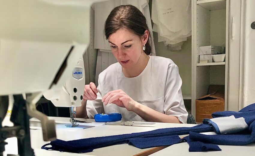 Bild zeigt Alina Dax in ihrem Schneideratelier an der Nähmaschine bei der Arbeit. (c) Schneideratelier Alina Dax